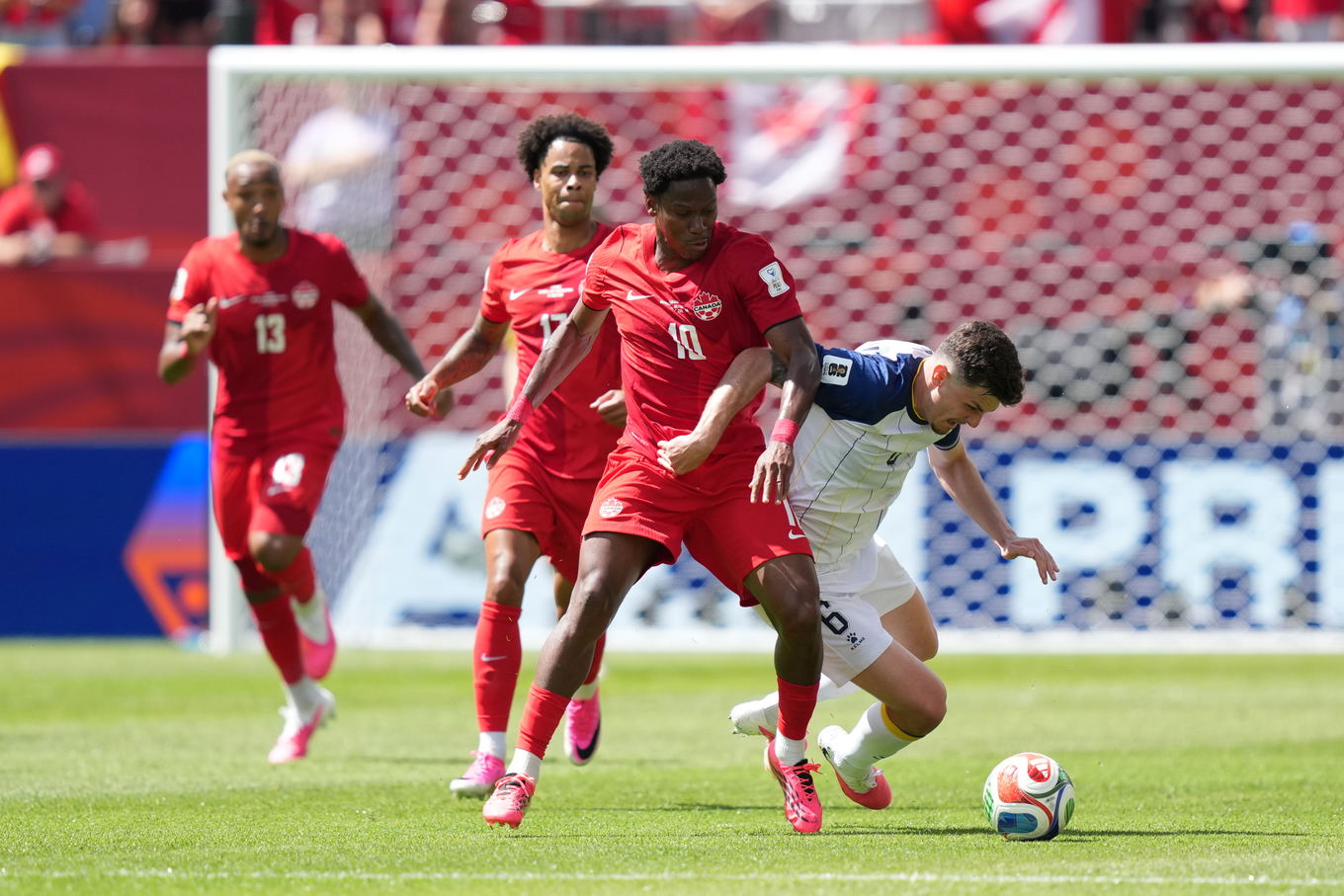 Jonathan David y Benjamin Tahirovic disputan el balón durante el partido de grupos del Mundial 2026 de Canadá